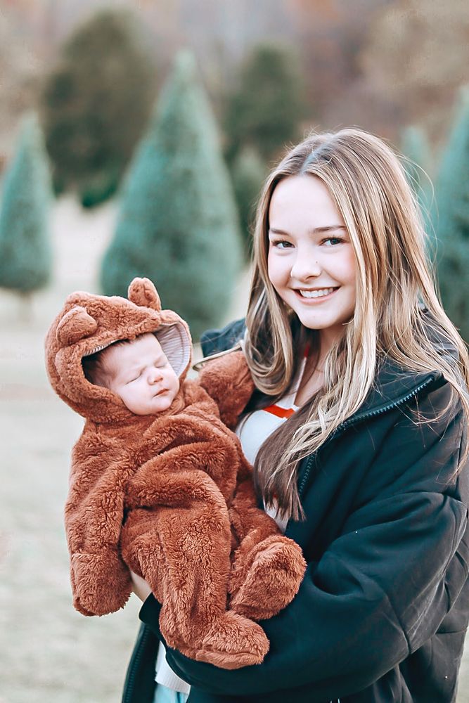 Baby in a bear suit at a Christmas tree farm